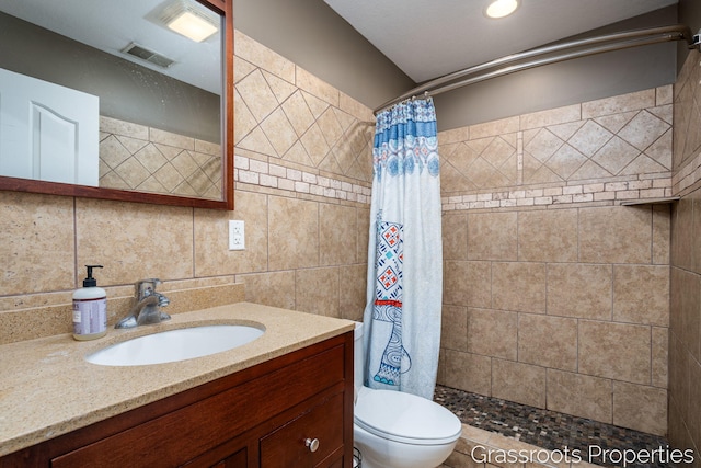 bathroom with walk in shower, toilet, tasteful backsplash, tile walls, and vanity