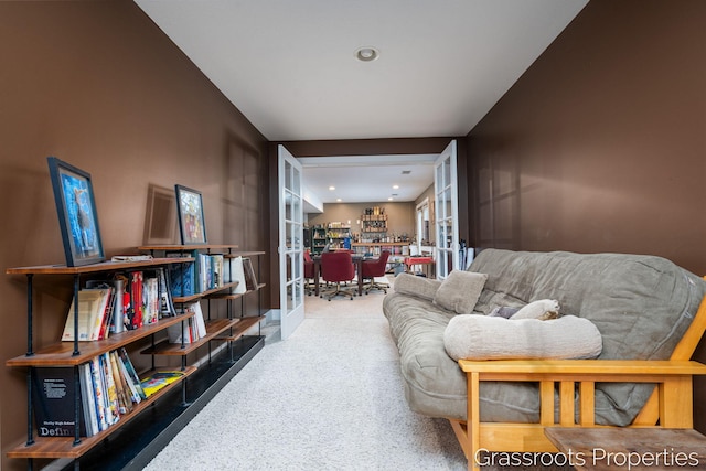 living area featuring french doors and carpet flooring