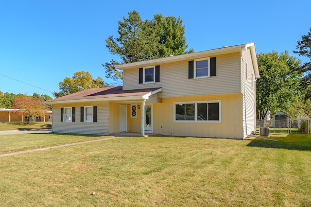 view of front facade with a front yard and central air condition unit