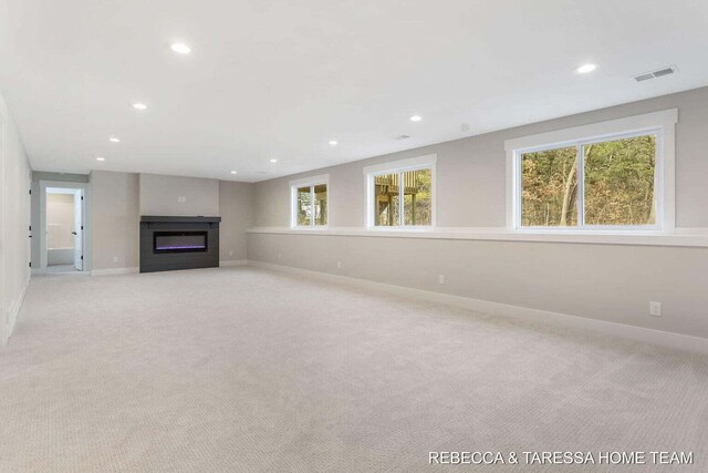 unfurnished living room featuring light carpet