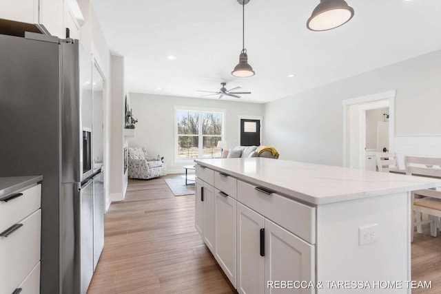 kitchen with hanging light fixtures, white cabinetry, light hardwood / wood-style flooring, and stainless steel fridge with ice dispenser