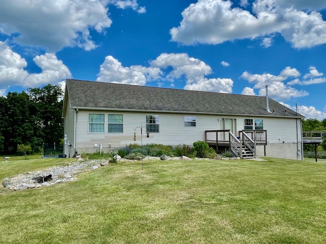 rear view of property featuring a trampoline, a yard, and a deck