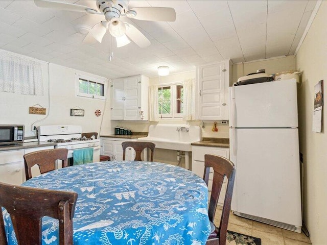 dining space with ceiling fan and light tile patterned floors