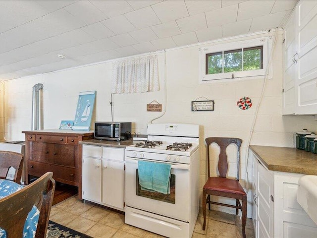 kitchen featuring white cabinetry and white range with gas stovetop