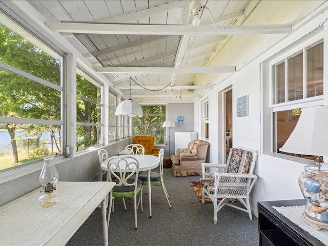 sunroom / solarium featuring beamed ceiling and wooden ceiling