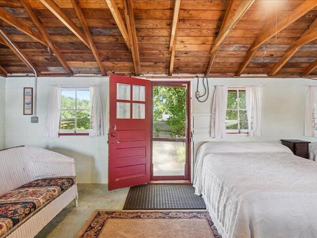 bedroom featuring lofted ceiling with beams, carpet, and wooden ceiling