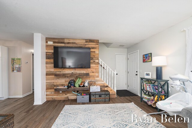 living room featuring dark wood-type flooring and wooden walls
