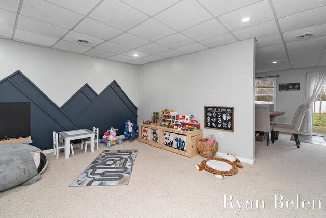 rec room with a paneled ceiling and carpet flooring