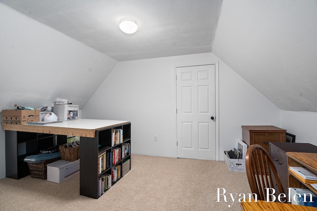 carpeted office space featuring vaulted ceiling