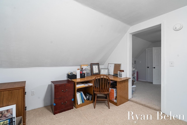 carpeted home office featuring vaulted ceiling