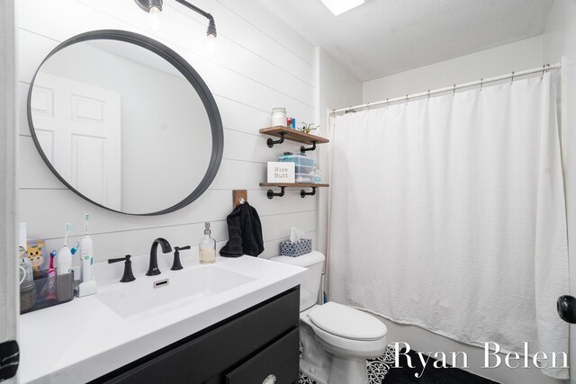 bathroom with vanity, curtained shower, and toilet
