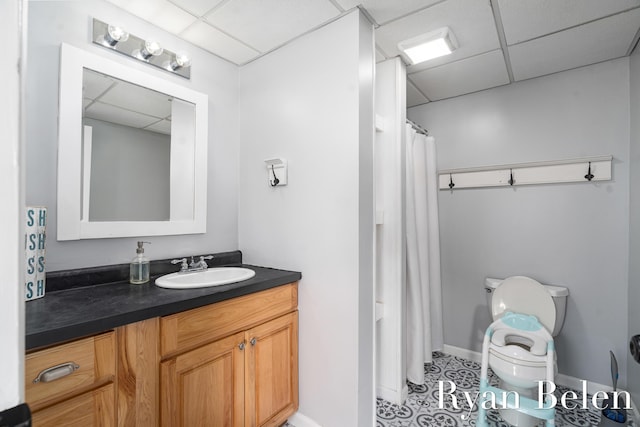 bathroom with a paneled ceiling, vanity, toilet, and a shower with shower curtain