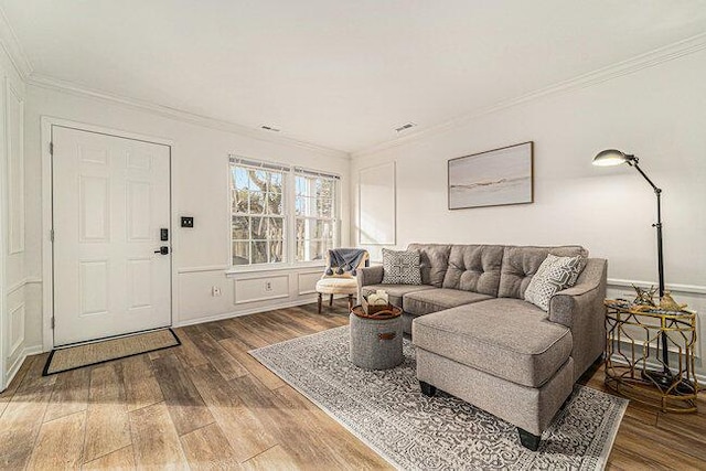 living room with crown molding and hardwood / wood-style flooring