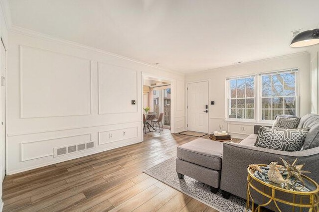 living room with wood-type flooring and ornamental molding