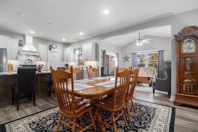 dining room with hardwood / wood-style flooring, ceiling fan, and vaulted ceiling