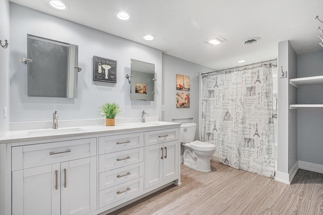 bathroom with vanity, toilet, curtained shower, and hardwood / wood-style floors