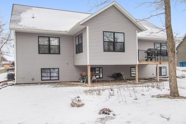 snow covered rear of property featuring central air condition unit