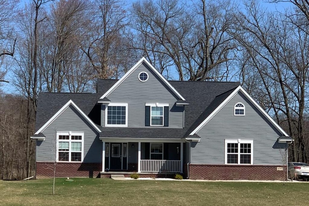 view of front of house featuring covered porch and a front lawn