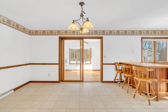 dining area featuring indoor bar, a notable chandelier, and baseboard heating