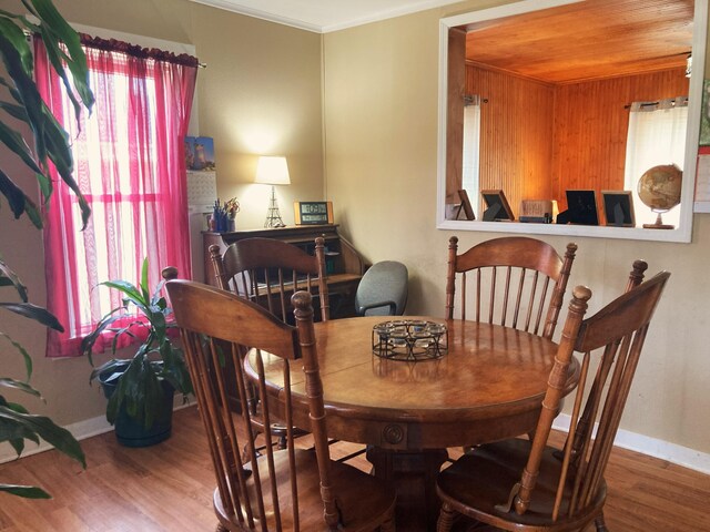 dining space featuring crown molding, wood ceiling, and wood-type flooring