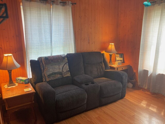 living room with hardwood / wood-style floors and wooden walls