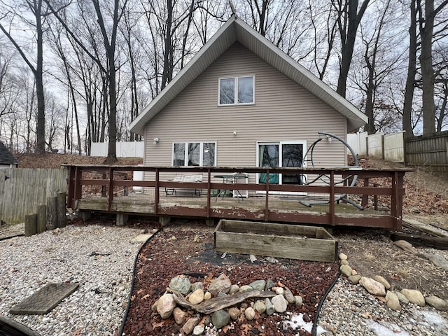 rear view of house featuring a wooden deck