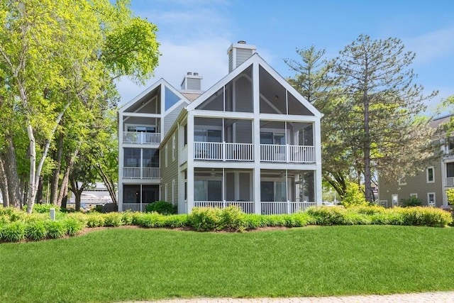420 Oselka Dr Unit 213, New Buffalo, MI 49117 - back of house featuring a chimney, a lawn, and a sunroom