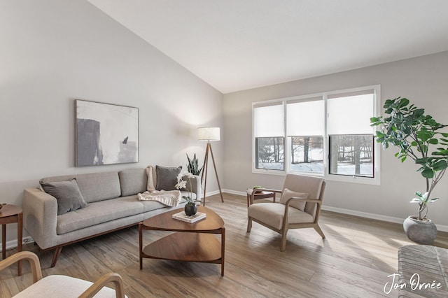 living room featuring lofted ceiling and light wood-type flooring