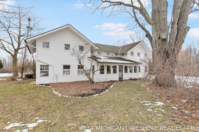 rear view of property featuring a lawn