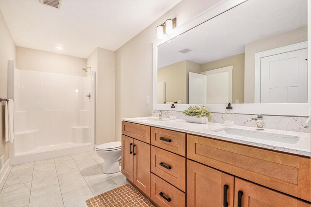 bathroom with vanity, toilet, and a shower