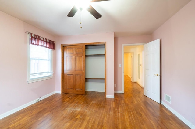 unfurnished bedroom featuring hardwood / wood-style flooring, a closet, and ceiling fan