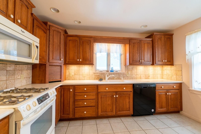 kitchen featuring sink, white appliances, decorative backsplash, and light tile patterned floors