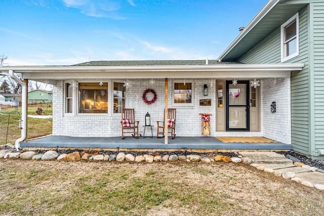 entrance to property with a lawn and a porch