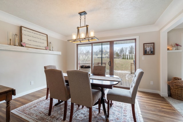 dining room with hardwood / wood-style flooring, a textured ceiling, and a chandelier