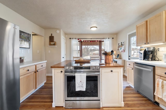 kitchen with wood counters, stainless steel appliances, dark hardwood / wood-style floors, and light brown cabinetry