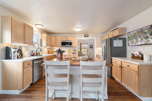 kitchen featuring light brown cabinetry, sink, dark hardwood / wood-style floors, and appliances with stainless steel finishes