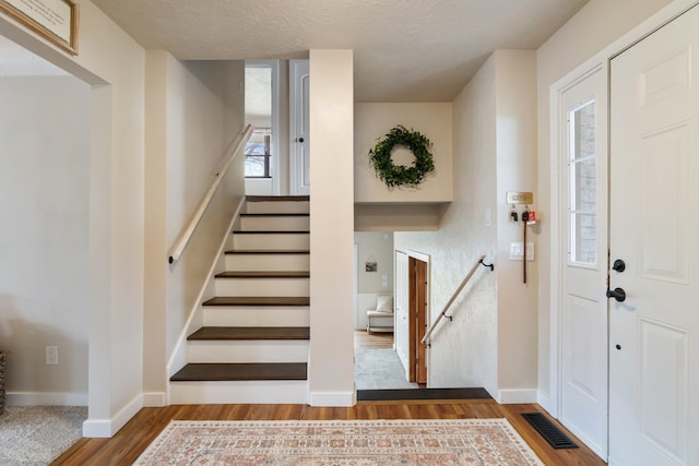 foyer entrance featuring hardwood / wood-style flooring and a textured ceiling