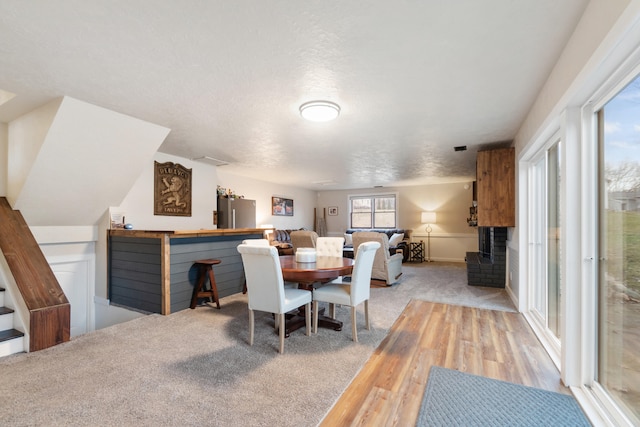 carpeted dining room featuring a textured ceiling