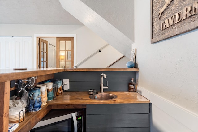 bar featuring butcher block countertops and sink