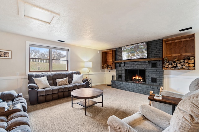 living room featuring a brick fireplace, light carpet, and a textured ceiling