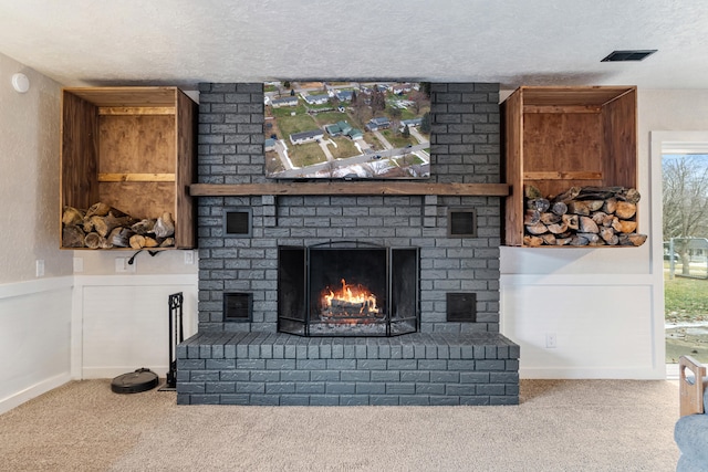 carpeted living room with a brick fireplace and a textured ceiling