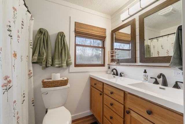 bathroom with vanity, a textured ceiling, and toilet