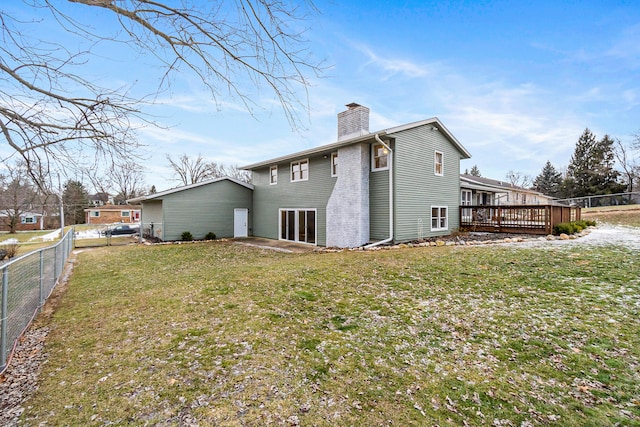 rear view of house with a wooden deck and a yard