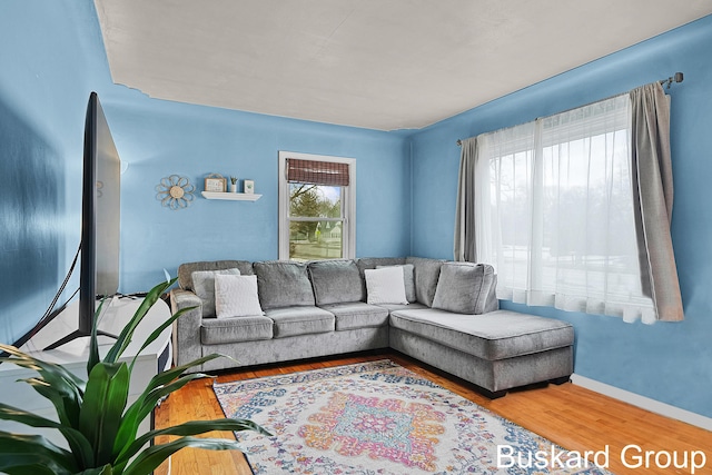 living area with baseboards and wood finished floors