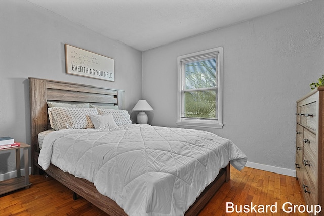 bedroom with baseboards and wood finished floors