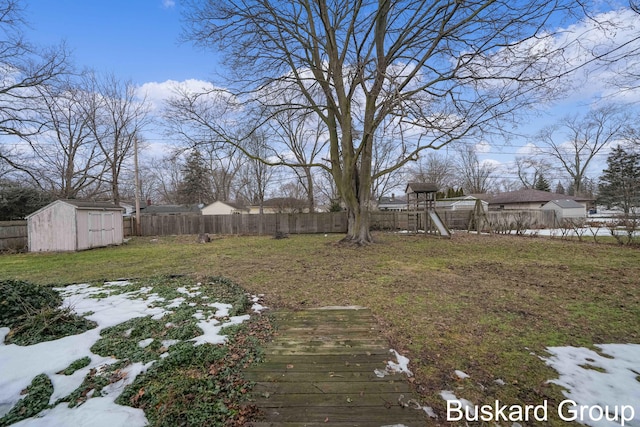 view of yard featuring a shed, a playground, a fenced backyard, and an outdoor structure