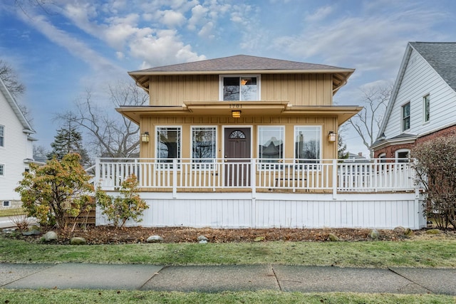 view of front facade featuring covered porch and a shingled roof