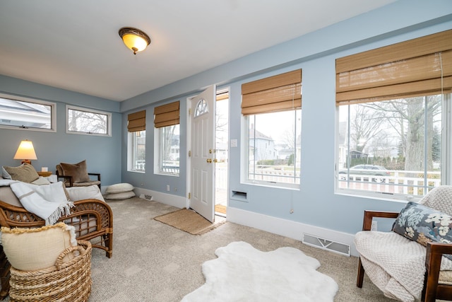 living area featuring light colored carpet, visible vents, and baseboards