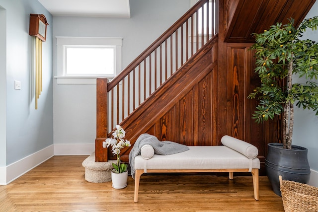 living area with light wood finished floors, stairway, and baseboards