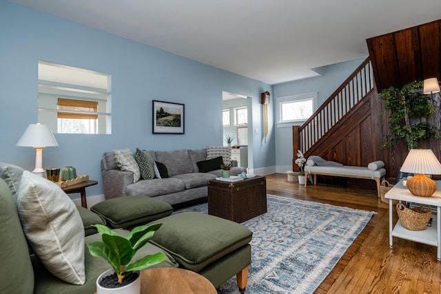 living area featuring dark wood-style floors, baseboards, and stairs